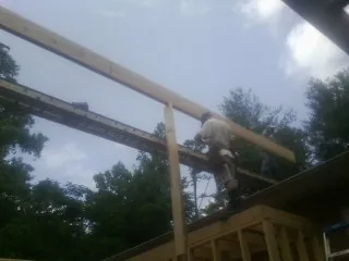 Carpenter setting a ridge beam over a new addition frame — Ice Dam Removal by Roofing Brothers in Oak Forest