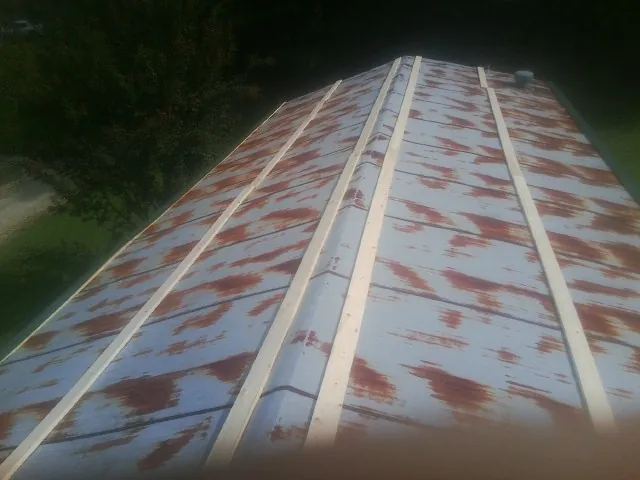 Rusted metal roof panels with new wood purlins before replacement — Storm Damage Roof Repair in Oak Forest by Roofing Brothers