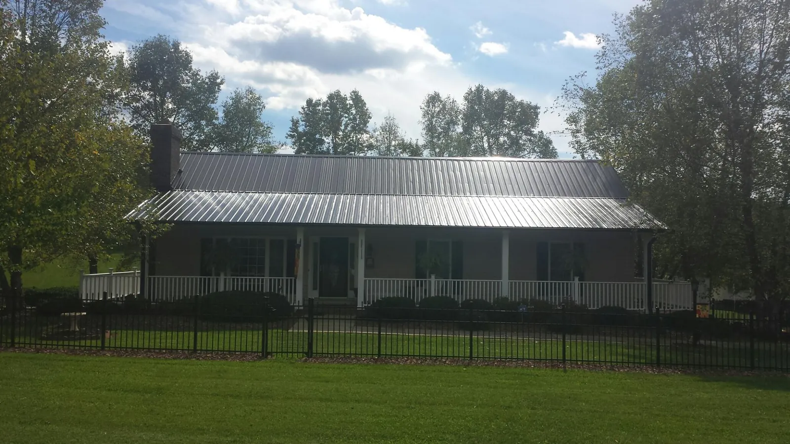 Gray metal roof on a brick ranch with a full width front porch — Gutter Guard Installation work by our crew in Oak Forest