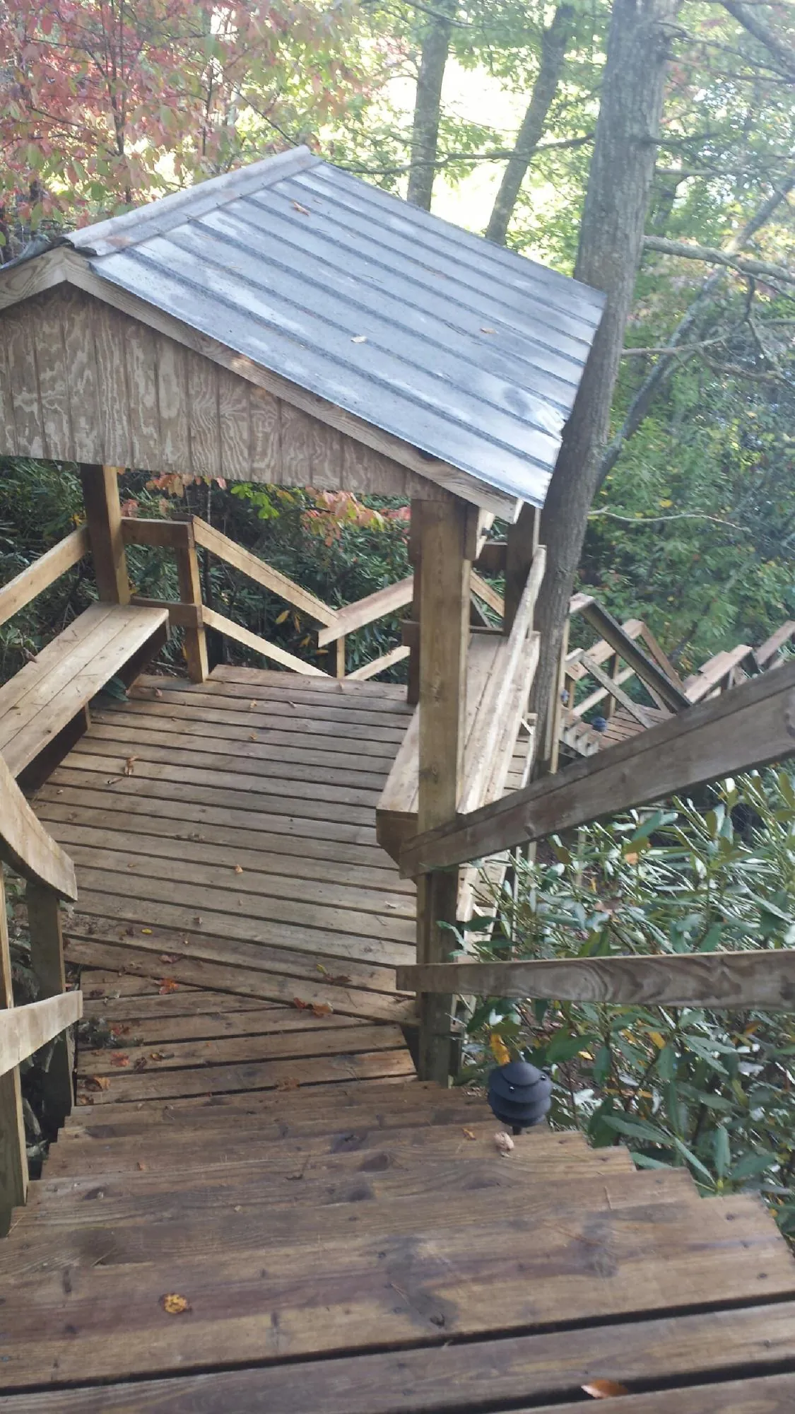 Metal roofed shelter over wooden steps on a wooded walkway — Skylight Repair & Installation work by our crew in Oak Forest